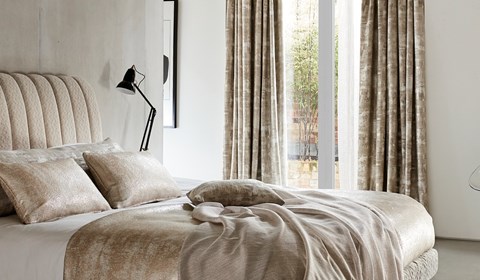 White and light gold bedding in bedroom